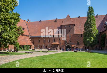 Touristen im Innenhof des historischen Schlosses von Malbork, Polen Stockfoto