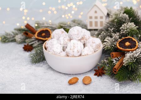 Traditionelle Weihnachts-Schneeballkekse mit Mandeln auf schneebedecktem Hintergrund Stockfoto