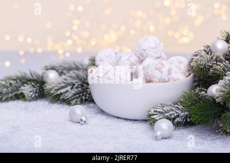 Traditionelle Weihnachts-Schneeballkekse mit Mandeln auf schneebedecktem Hintergrund Stockfoto