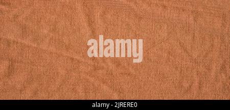 Warme, braun-orange gefärbte, helle Strickware flach liegend. Warmer handgefertigter Pullover aus bräunlich-gelber Senfwolle Stockfoto