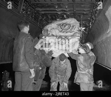 Royal Air Force 1939-1945 - Bomber Command Bodenpersonal von No 514 Squadron in Edinburgh Last Zement Taschen voller Lebensmittel in die Bombe Schacht eines Lancaster, 29. April 1945. Das Essen würde zu den Hungernden Niederländische fallen jene Teile von Holland immer noch von den Deutschen besetzt, als Teil der Operation 'Manna'. Stockfoto