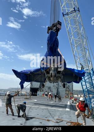 Blick auf eine F/A-18E Super Hornet, aufgenommen am 16. August 2022, vor der Küste Siziliens, Italien, als sie auf das große mittelschnelle Roll-on-Roll-off-Schiff USNS Mendonca (T-AKR 303) des Military Sealift Command für den Transport in die Vereinigten Staaten abgesenkt wurde. Das Flugzeug, das Anfang des Jahres bei starkem Wetter vom Flugzeugträger USS Harry S. Truman (CVN 75) abgeblasen wurde, wurde mit einem ferngesteuerten Fahrzeug CURV-21 9.500 Fuß unter dem Mittelmeer geborgen, um spezielle Takelage- und Aufzugslinien an das Flugzeug zu befestigen. Foto über U.S. Navy/UPI Stockfoto