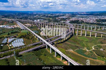 (220824) -- HONGHE, 24. August 2022 (Xinhua) -- Luftfoto vom 23. August 2022 zeigt einen umfassenden Inspektionszug, der auf der Mile-Mengzi Hochgeschwindigkeitsbahn in der Nähe der Mile Station in Honghe Hani und der autonomen Präfektur Yi, südwestlich der Provinz Yunnan, fährt. Die 107 km lange Eisenbahn mit einer Geschwindigkeit von 250 Stundenkilometern startete kürzlich einen Testlauf. (Xinhua/Chen Xinbo) Stockfoto