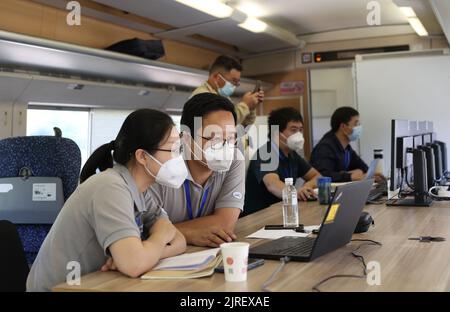 (220824) -- HONGHE, 24. August 2022 (Xinhua) -- Mitarbeiter arbeiten an einem umfassenden Inspektionszug auf der Mile-Mengzi-Hochgeschwindigkeitsbahn in Honghe Hani und der autonomen Präfektur Yi, südwestlich der chinesischen Provinz Yunnan, 23. August 2022. Die 107 km lange Eisenbahn mit einer Geschwindigkeit von 250 Stundenkilometern startete kürzlich einen Testlauf. (Foto von He Lyupeng/Xinhua) Stockfoto