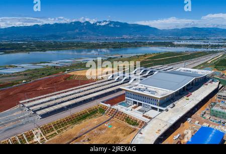 (220824) -- HONGHE, 24. August 2022 (Xinhua) -- Luftfoto vom 24. August 2022 zeigt den Honghe Bahnhof der Mile-Mengzi Hochgeschwindigkeitsbahn in der Autonomen Präfektur Honghe Hani und Yi, südwestlich der Provinz Yunnan in China. Die 107 km lange Eisenbahn mit einer Geschwindigkeit von 250 Stundenkilometern startete kürzlich einen Testlauf. (Xinhua/Chen Xinbo) Stockfoto