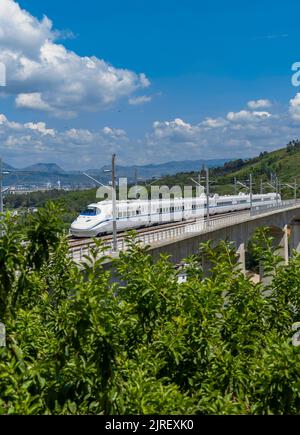 (220824) -- HONGHE, 24. August 2022 (Xinhua) -- das Foto vom 23. August 2022 zeigt einen umfassenden Inspektionszug, der auf einer großen Brücke der Mile-Mengzi-Hochgeschwindigkeitsbahn in Honghe Hani und der Autonomen Präfektur Yi, südwestlich der Provinz Yunnan, fährt. Die 107 km lange Eisenbahn mit einer Geschwindigkeit von 250 Stundenkilometern startete kürzlich einen Testlauf. (Foto von Wu Yu/Xinhua) Stockfoto