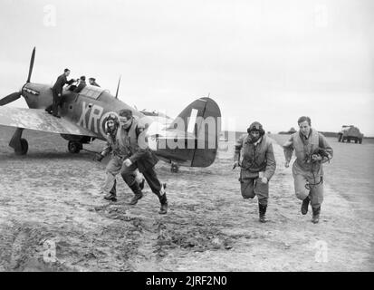 Amerikanische Piloten von Nr. 71 "Eagle" geschwader Ansturm auf die Hawker Hurricanes an kirton-in-Lindsey, 17. März 1941. Amerikanische Piloten von Nr. 71 "Eagle" geschwader Ansturm auf die Hurrikane an kirton-in-Lindsey, 17. März 1941. Stockfoto