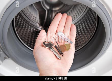 Metallgegenstände in der Waschmaschine, die die Waschmaschine beschädigen, wenn sie in den Taschen liegen. Haarspange, Haarrosa, Schlüssel, Münzen, Nagel, Schraube, Büroklammer. Stockfoto