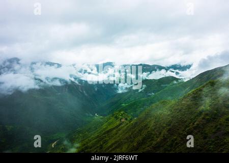 Hügel im Himalaya mit grünen Bäumen, die von Nebel bedeckt sind, und weißen Wolken nach einem Regen. Uttarakhand Indien. Stockfoto