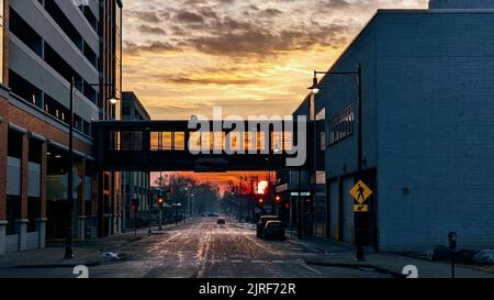 Eine Stadtstraße bei schönem Sonnenaufgang mit einem orangefarbenen Himmel an einem Wochentag Stockfoto