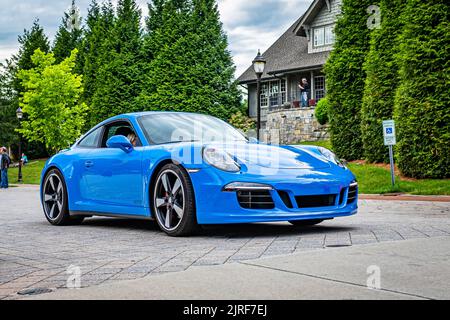 Highlands, NC - 10. Juni 2022: Vorderansicht eines Porsche 911 Carrera GTS Club Coupés aus dem Jahr 2016, das eine lokale Automobilausstellung verlässt. Stockfoto