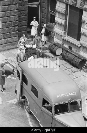 Guy's Hospital - Leben in einem Londoner Krankenhaus, England, 1941 ein Unfall ist auf einer Bahre zu einem wartenden Rettungswagen am Guy's Hospital in London durchgeführt. Der Krankenwagen war für die amerikanischen Krankenwagen Großbritannien von Fred ein Armer von Chicago USA, Juni 1940" vorgestellt. Eine Frau aus der Amerikanischen Krankenwagen Großbritannien können auf der linken Seite des Fotos halten eine Decke gesehen werden. Stockfoto