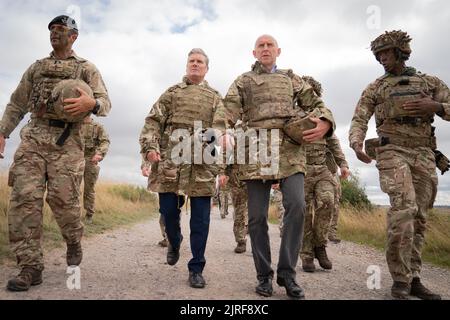 Der Gewerkschaftsführer Sir Keir Starmer und der Schattenverteidigungsminister John Healey (Mitte rechts) treffen auf britische Soldaten in der Salisbury Plain in Wiltshire, wo er ukrainische Soldaten im Rahmen der Operation Interflux von der Armee trainieren sah. Bilddatum: Mittwoch, 24. August 2022. Stockfoto