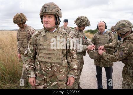 Der Gewerkschaftsführer Sir Keir Starmer und der Schattenverteidigungsminister John Healey (Mitte rechts) treffen auf britische Soldaten in der Salisbury Plain in Wiltshire, wo er ukrainische Soldaten im Rahmen der Operation Interflux von der Armee trainieren sah. Bilddatum: Mittwoch, 24. August 2022. Stockfoto