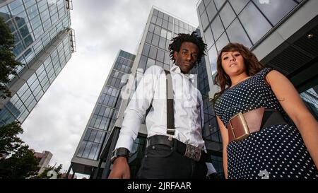Geschäftspartner. Eine starke, selbstbewusste Pose eines elegant gekleideten professionellen Paares in ihrem heimischen Unternehmensumfeld. Aus einer Reihe von Bildern. Stockfoto