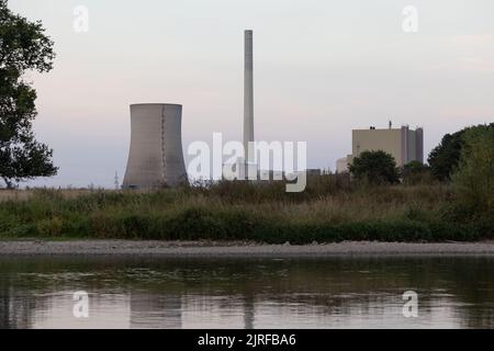 Petershagen, Deutschland. 23. August 2022. Blick auf das Heyden Steinkohlekraftwerk hinter der Weser. Um Erdgas zu sparen, steht ein weiteres Steinkohlekraftwerk aus der Reserve in Deutschland vor dem Neustart. Es handelt sich um das Heyden-Kraftwerk in Petershagen, Nordrhein-Westfalen, an der Grenze zu Niedersachsen. Laut Betreiber Uniper soll die Markteinführung vom kommenden Montag bis Ende April 2023 wieder aufgenommen werden. Quelle: Friso Gentsch/dpa/Alamy Live News Stockfoto