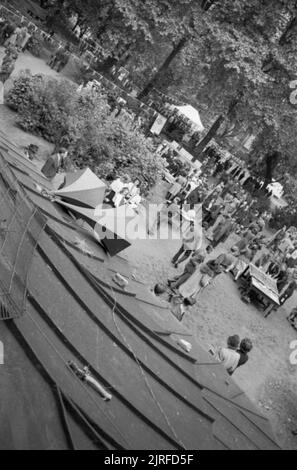 Krieg Fair - Urlaub zu Hause auf einer Fete in Russell Square, London, 1943 eine Luftaufnahme der Sehenswürdigkeiten auf dieser Messe in London Russell Square gehalten wird. Die Lautsprecher im Vordergrund werden verwendet, um die Besucher des Angebots zu informieren. In den Hintergrund, die Menschen spielen und an verschiedenen Ständen, und die Umgebung ist mit Fahnen und wimpelketten geschmückt. Stockfoto