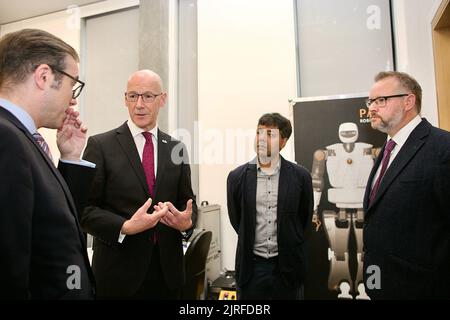 Edinburgh, Großbritannien, 24.. August 2022: Schottlands stellvertretender erster Minister John Swinney, zweiter von links, besucht das Bayes Centre mit (links) Michael Rovatsos, Direktor des Bayes Centre, Universität Edinburgh, Sethu Vijayakumar von der School of Informatics und Brian Hills, CEO des Data Lab. Bild: TERRY MURDEN / Alamy Stockfoto