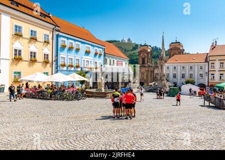 Mikulov, Tschechische Republik - 8,8.2020: Radfahrer und Touristen auf dem Hauptplatz in Mikulov Stadt. Mittelalterliche Stadt mit magischen Straßen und schöne Stadt hal Stockfoto