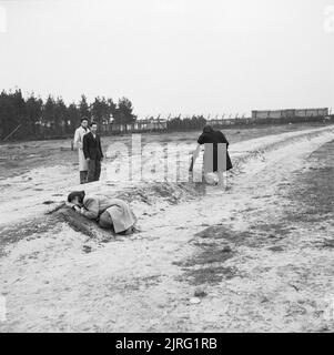 Der erste Jahrestag der Befreiung der Konzentrationslager Bergen Belsen, April 1946 Zwei ehemalige weibliche Häftlinge weint über eines der massengräber. Stockfoto