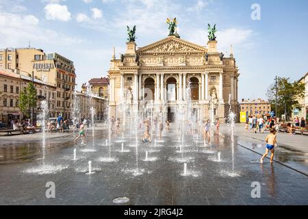 Lviv, Ukraine - 24. August 2022: Kinder spielen im Brunnen in der Nähe der Nationaloper von Lviv Stockfoto