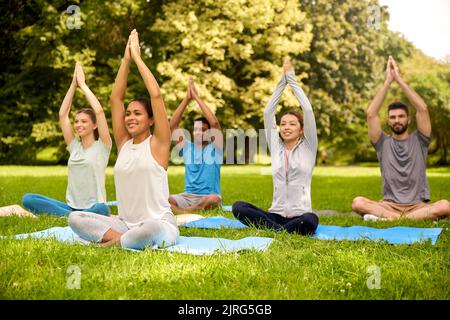 Eine Gruppe von Menschen, die im Sommerpark Yoga machen Stockfoto