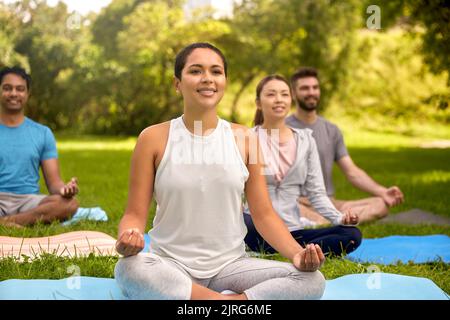 Eine Gruppe von Menschen, die im Sommerpark Yoga machen Stockfoto