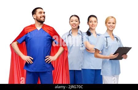 Männlicher Arzt im Superhelden-Cape und weibliche Krankenschwestern Stockfoto