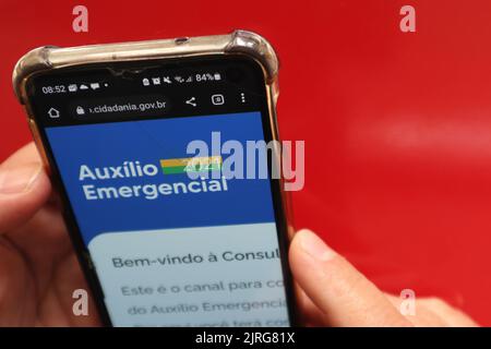 Draufsicht auf das Smartphone mit der Hand auf rotem Hintergrund. Stockfoto