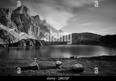 Eine Graustufenaufnahme der felsigen Berge, die sich im See spiegeln, Lago Rienza, Italien, Europa Stockfoto