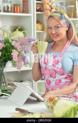 Junge Frau kocht Salat in der Küche Stockfoto