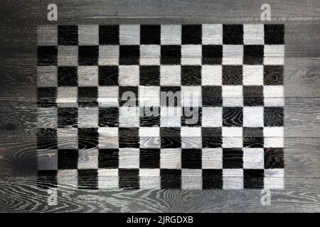 Karierte Flagge auf rustikalem alten Holz Oberfläche Hintergrund Stockfoto