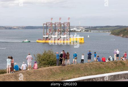 Cork Harbour, Cork, Irland. 24.. August 2022. Eine kleine Menschenmenge traf sich in Camden in Crosshaven, um den Abflug von drei Containerkranen zu beobachten, die Cork Harbour auf dem Deck des Schiffes Biglift Baffin verlassen und nach New Jersey, USA, fahren. Die von Liebherr in Killarney gebauten Krane sind die größten Einzelobjekte, die jemals in Irland entwickelt wurden und aus dem Land verschickt werden. Kredit; David Creedon / Alamy Live Nachrichten Stockfoto