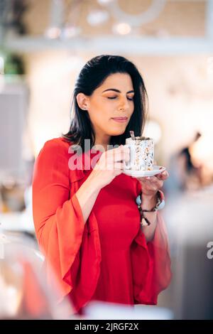 Hübsche Frau genießt den Duft eines Kaffees mit geschlossenen Augen Stockfoto