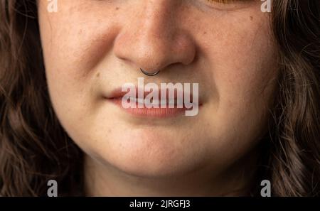 Nahaufnahme einer jungen Frau, die ihre Nase hochdreht Stockfoto
