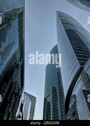 Blick von unten auf Wolkenkratzer und blauen Himmel. Moderne Bürogebäude im Finanzviertel Stockfoto
