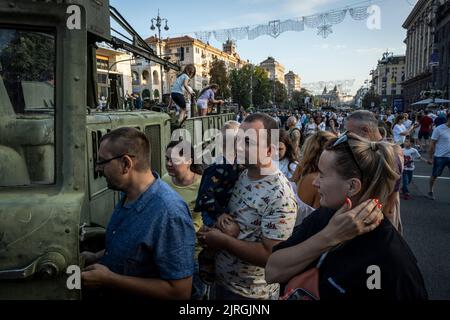 Kiew, Oblast Kiew, Ukraine. 21. August 2022. Eltern und ihre Kinder stellten sich auf, um das Innere eines zerstörten russischen Militärfahrzeugs auf den Straßen von Kiew zu sehen. Zum bevorstehenden Unabhängigkeitstag der Ukraine und fast 6 Monate nach der umfassenden Invasion der Ukraine am 24. Februar veranstaltet die Hauptstadt Kiew in der Hauptstraße der Chreschajtk-Straße eine Ausstellung mit mehreren zerstörten Militärgeräten, Panzer und Waffen der Streitkräfte der Russischen Föderation (AFRF) als die russische vollständige Invasion der Ukraine am 24. Februar begann, hat der Krieg, der kil Stockfoto