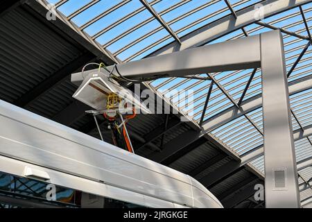 Amsterdam, Niederlande - August 2022: Nahaufnahme eines öffentlichen Busses, der an eine Schnellladestation in der Bushaltestelle Centraal angeschlossen ist Stockfoto