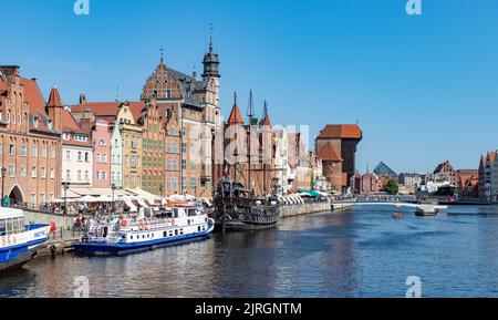 Ein Bild von einigen Danziger Sehenswürdigkeiten neben dem Fluss Motlawa, wie dem Kranich, dem Marien-Tor und dem Schiff der Schwarzen Perle. Stockfoto