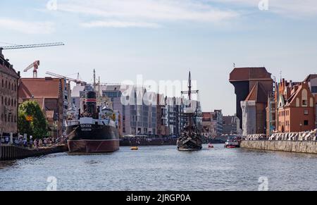 Ein Bild von einigen Danziger Sehenswürdigkeiten neben dem Fluss Motlawa, wie dem Kranich (rechts), dem Soldek Schiffsmuseum (links) und dem Schiff der Schwarzen Perle (Cent Stockfoto