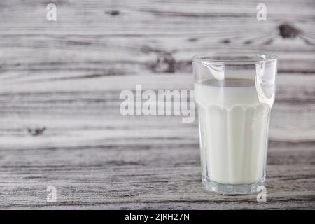 Glas frischer Milch auf dem hölzernen Vintage-Hintergrund mit Kopierfläche. Bio-Milch. Gesunder Wellness-Hintergrund. Hochwertige Fotos Stockfoto