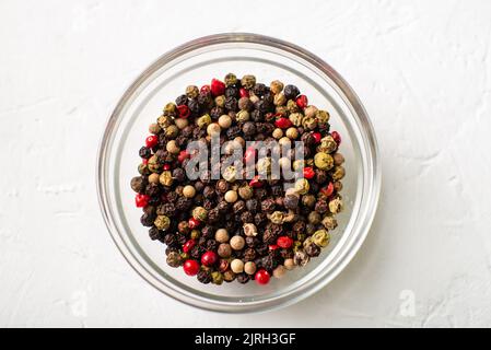 Verschiedene Arten von Paprika in einer Glasplatte. Weißer Hintergrund. Makro. Stockfoto