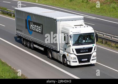 MAN TGX LKW mit Henzel Curtainside Anhänger auf der Autobahn Stockfoto