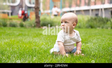 Kleines Baby auf frischem grünen Gras im Freien Stockfoto