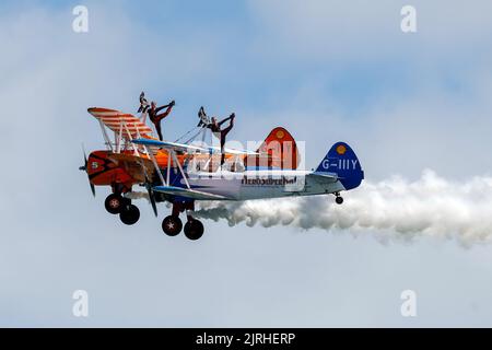 Eastbourne, East Sussex, Großbritannien. Mit den Aerosuperbatics Wingwalkers auf der jährlichen Eastbourne Airshow vom Strand in Eastbourne aus gesehen. 18.. August 2022. Credit David Smith/Alamy Live News Stockfoto