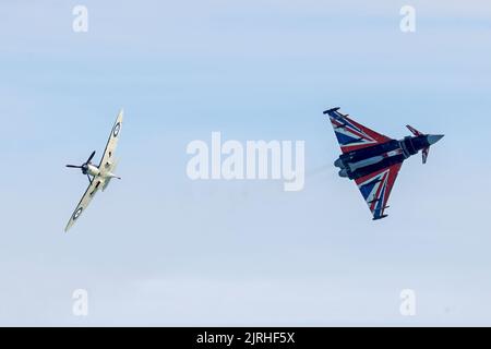 Eastbourne, East Sussex, Großbritannien. Mit dem RAF Typhoon in Kombination mit einem AT the Battle of Britain Spitfire auf der jährlichen Eastbourne Airshow, die vom Strand in Eastbourne aus gesehen wird. 20.. August 2022. Credit David Smith/Alamy Live News Stockfoto