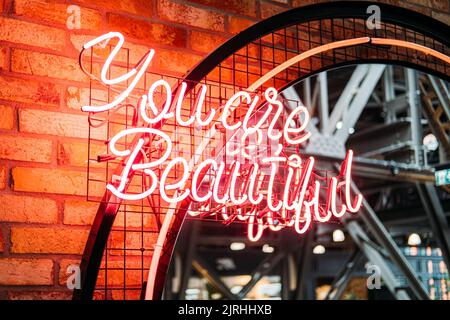 Du bist ein schönes rotes Neonschild. Motivation roter Neon Text Du bist schön an der Wand Stockfoto