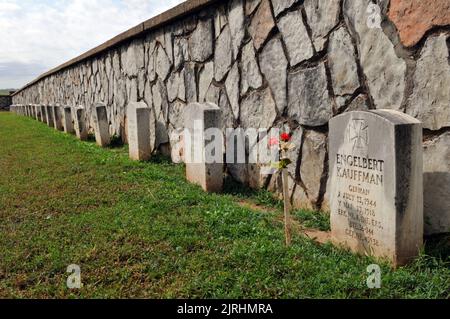 Die Gräber deutscher Soldaten, die während des Zweiten Weltkriegs gefangen genommen wurden, säumen eine Steinmauer auf dem historischen Friedhof in Fort Reno, Oklahoma. Stockfoto