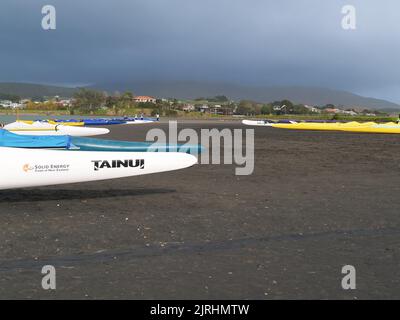 Raglan, Neuseeland - 7 2008. Juni Menschen und Waka-ama oder Kanus am Ufer von Raglan Stockfoto