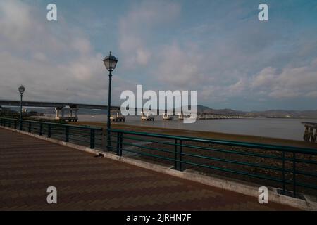 Bahia de Caraquez, Manabi / Ecuador - August 20 2022: Fahrzeuge fahren auf der Brücke, die die Stadt Bahia de Caraquez mit dem San Vicente See verbindet Stockfoto